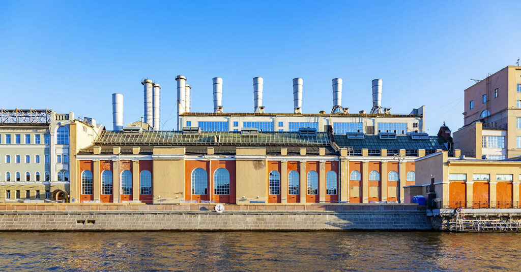 Ein altes Fabrikgebäude an einem Fluß in einem Industriegebiet