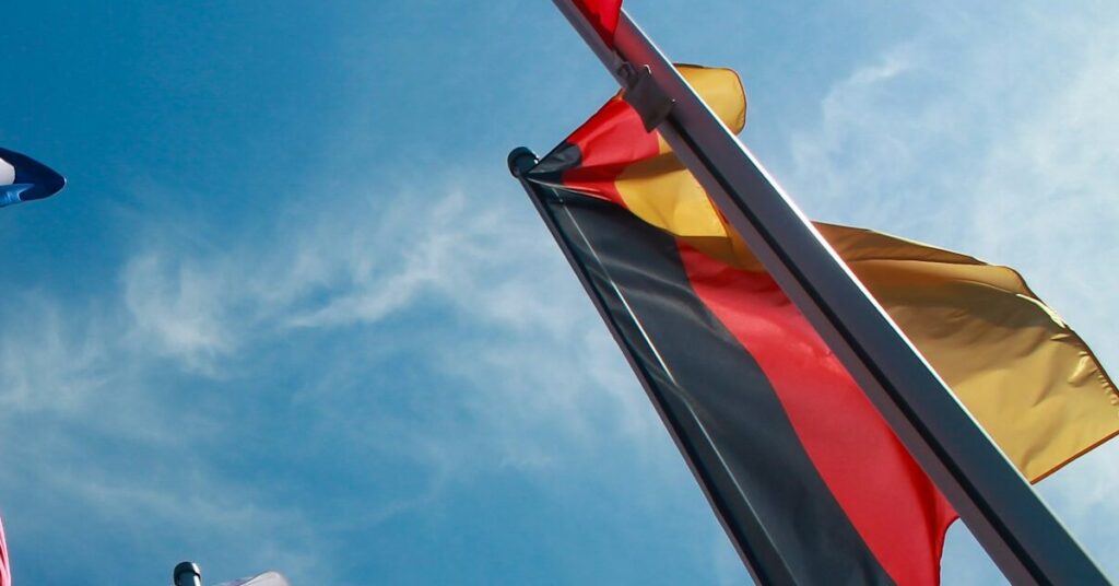 Flagge von Deutschland an einem Fahnenmast, rundherum weitere Fahnenmasten